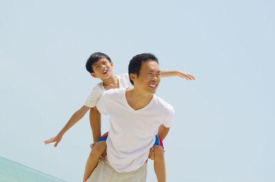 Young couple smiling against clear sky