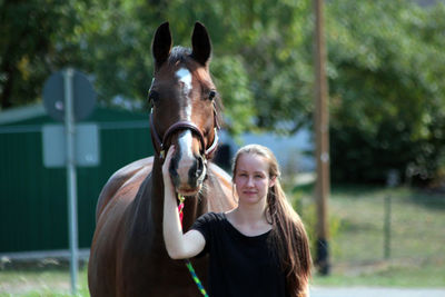 Portrait of young woman with horse