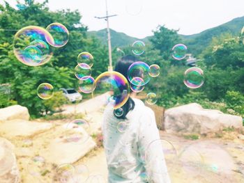 Close-up of bubbles with women against mountain