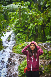 Portrait of smiling woman standing against plants