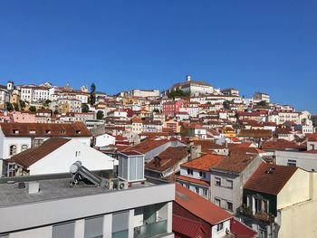 Houses in town against clear blue sky