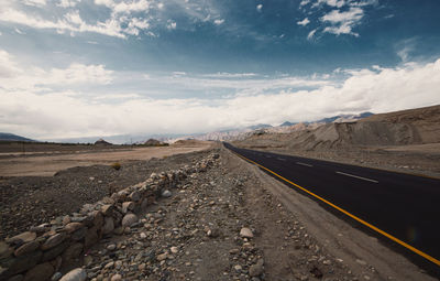 Road passing through landscape against sky