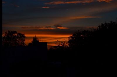 Silhouette trees against sky at sunset