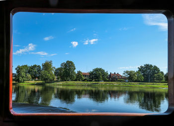 Scenic view of lake by trees against sky