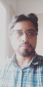 Portrait of man wearing eyeglasses at home