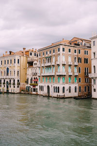 Buildings by sea against sky