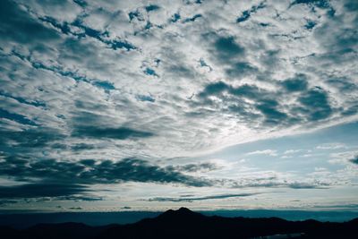 Low angle view of silhouette mountain against dramatic sky