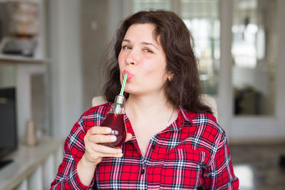 Portrait of smiling woman drinking drink