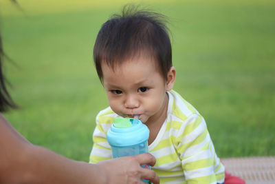 Close-up of cute boy sitting at park