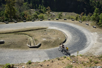 High angle view of men cycling on winding road