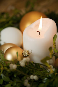 Close-up of illuminated candle and wreath