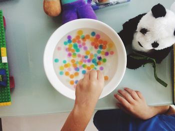 Cropped image of boy playing with multi colored water orbs