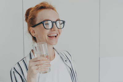 Portrait of a smiling young woman drinking glass