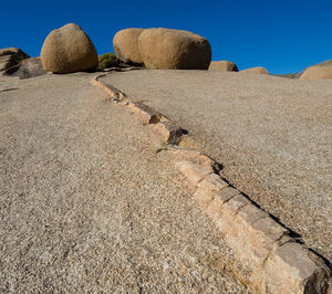 Rocks on sand against sky