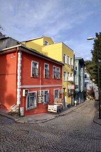 Buildings by street against sky in city
