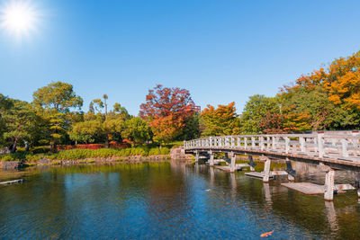 Bridge over river against sky during autumn