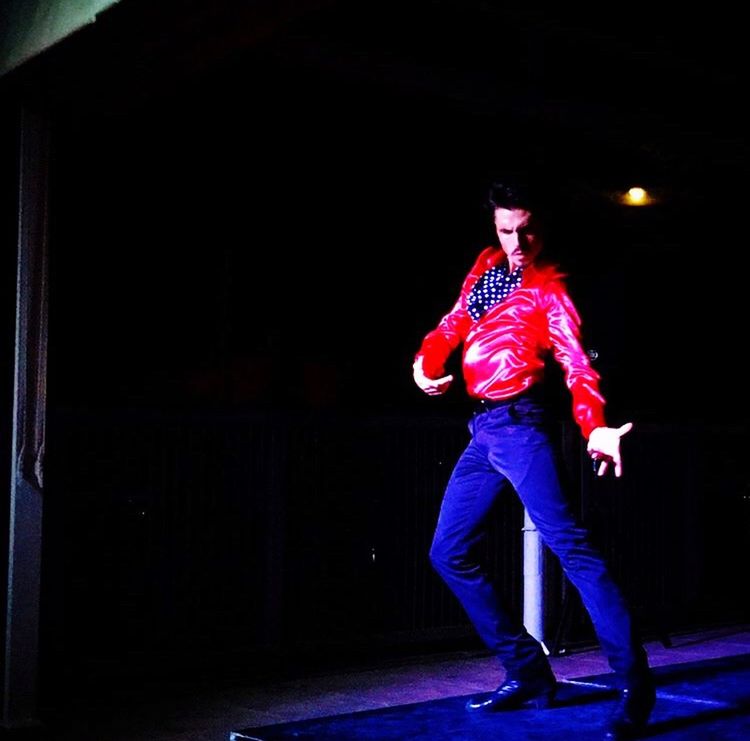 FULL LENGTH OF MAN STANDING AGAINST ILLUMINATED STAGE