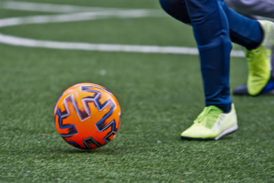 Low section of man playing soccer on field