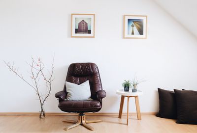 Empty living room with luxurious chair against wall