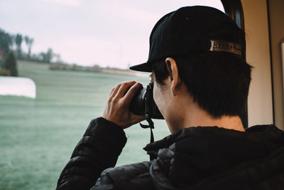 Man photographing sea against sky