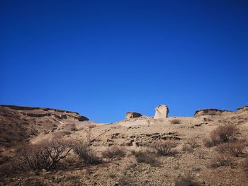 Scenic view of desert against clear blue sky