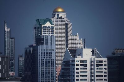 Buildings in city against blue sky