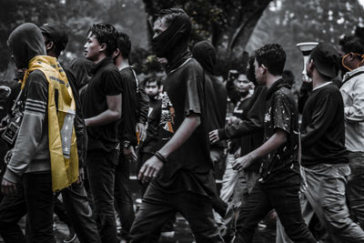 Rear view of people standing in city