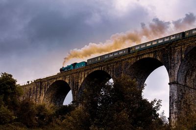 Low angle view of arch bridge against sky