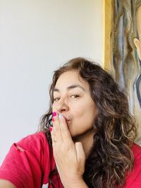 Portrait of smiling woman against wall