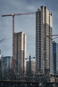 Low angle view of buildings during construction against sky in city