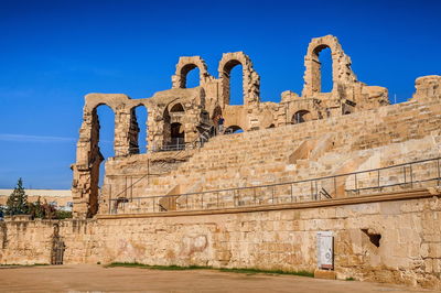 Low angle view of old ruin building against blue sky