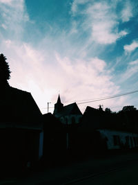 Low angle view of silhouette buildings against sky