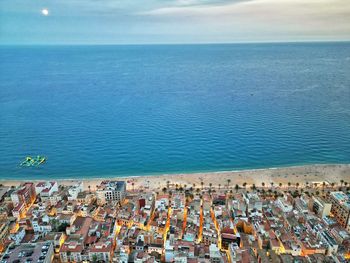 High angle view of townscape by sea against sky