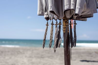 Close-up of clothes hanging on beach against sky
