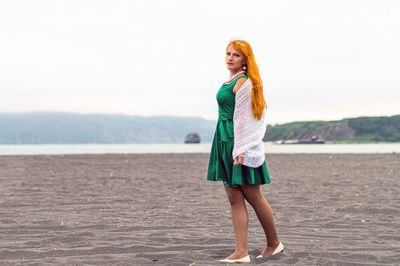 Portrait of young woman standing at beach