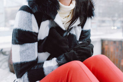 Woman sitting in city in winter