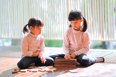 Siblings sitting on floor