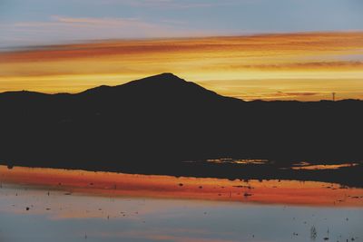 Scenic view of silhouette mountains against sky during sunset