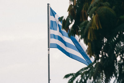 Low angle view of flag against blue sky