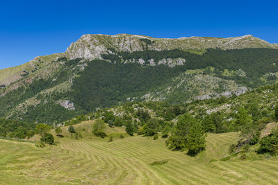 Scenic view of mountains against clear blue sky