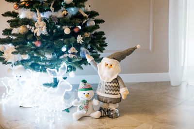 Christmas gnome, glowing deer and snowman under the christmas tree