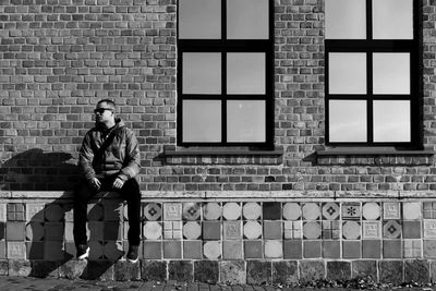 Full length of man on brick wall