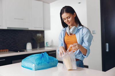 Portrait of young woman standing at home