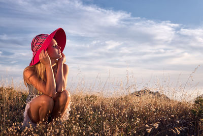 Young woman on field against sky