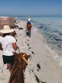 Side view of woman with dog on beach