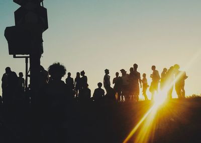 Silhouette people photographing against clear sky during sunset