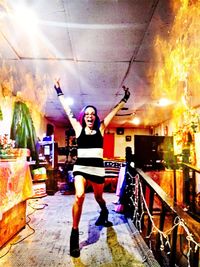 Full length portrait of woman standing against fire