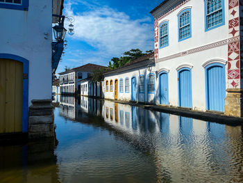 Reflection of buildings in canal against sky