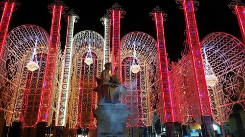 Low angle view of illuminated lighting equipment at night