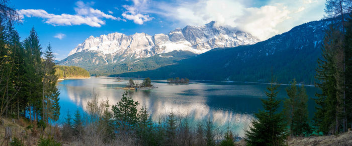 Scenic view of lake by mountains against sky